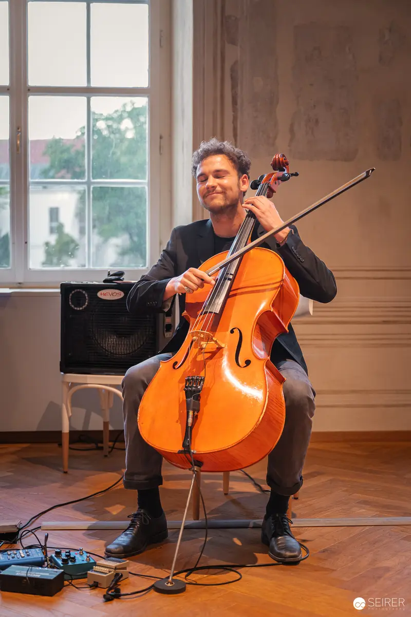 Cellist Performing with Electronic Effects at Book Presentation in Josephinum