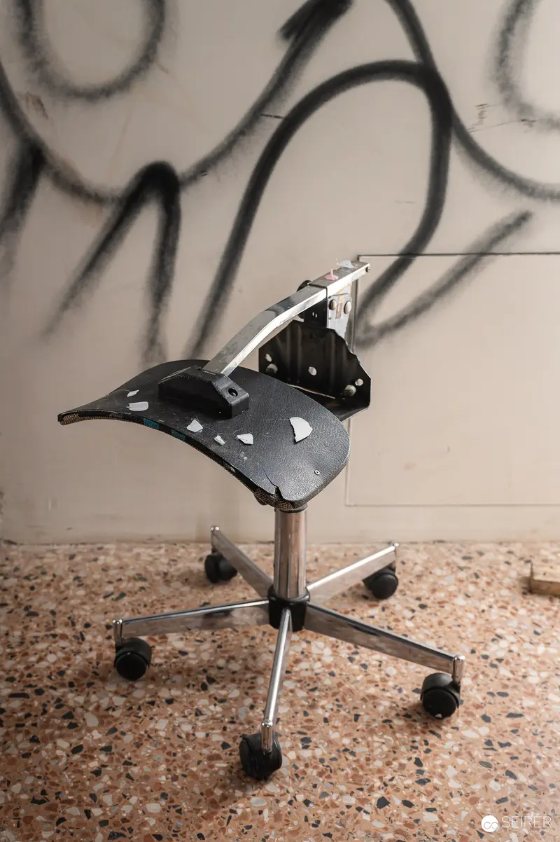 Office Chair Sculpture Against Graffitied Wall at Art Exhibition