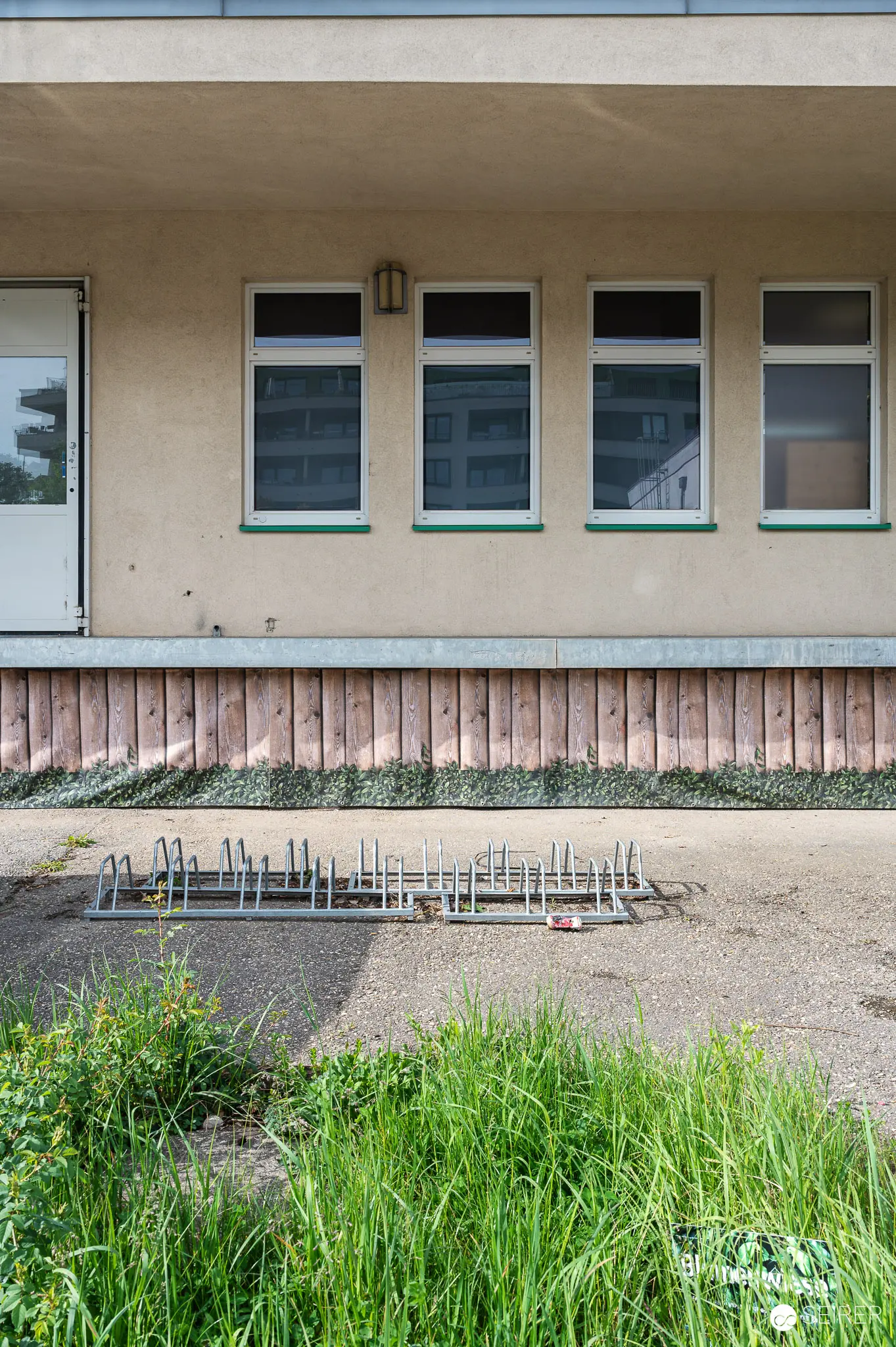 Building Construction Site with Exposed Rebar Foundation and Horizontal Wood Paneling