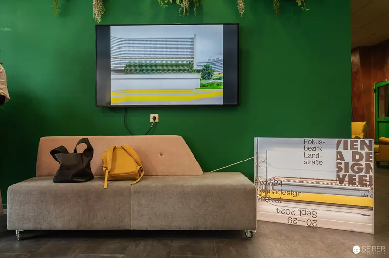 Modern Exhibition Display with Green Wall and Architectural Imagery Screen