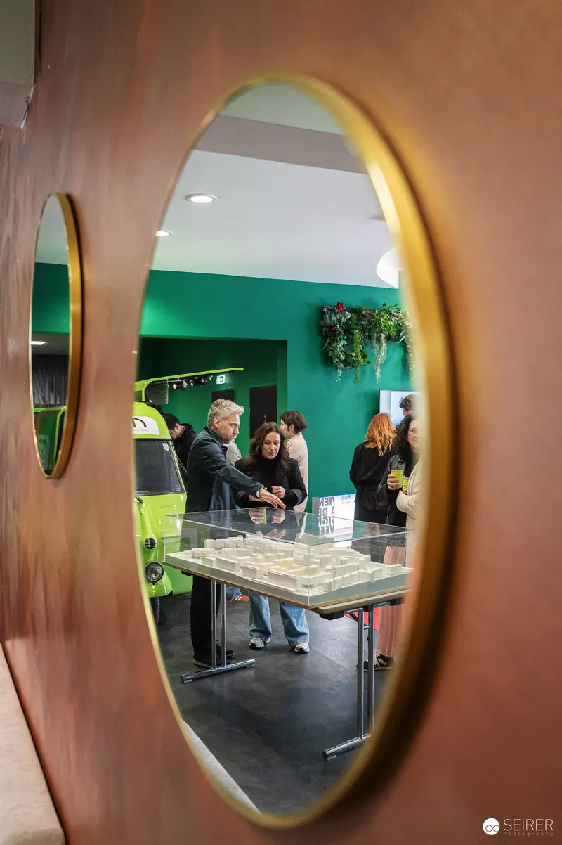 Press Briefing Viewed Through Circular Golden-Framed Window