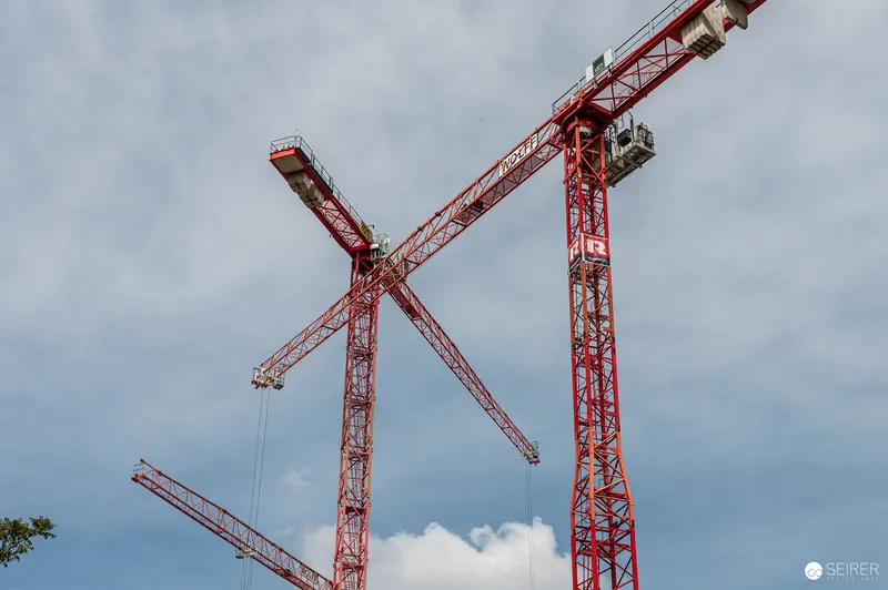 Red Construction Cranes at Industrial Building Site