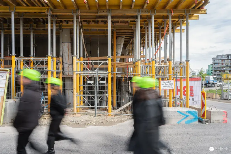 Construction Workers in High-Visibility Gear at Active Building Site Press Preview