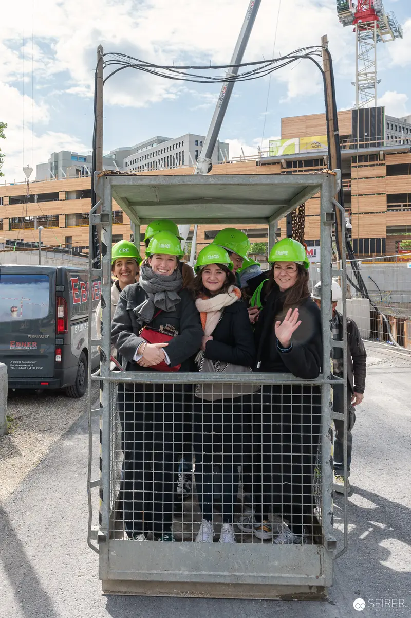 Four Workers in Green Hard Hats Experience Construction Site Personnel Lift