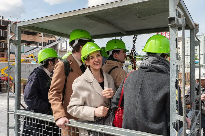 Construction Site Tour Group in Safety Helmets on Elevator Platform