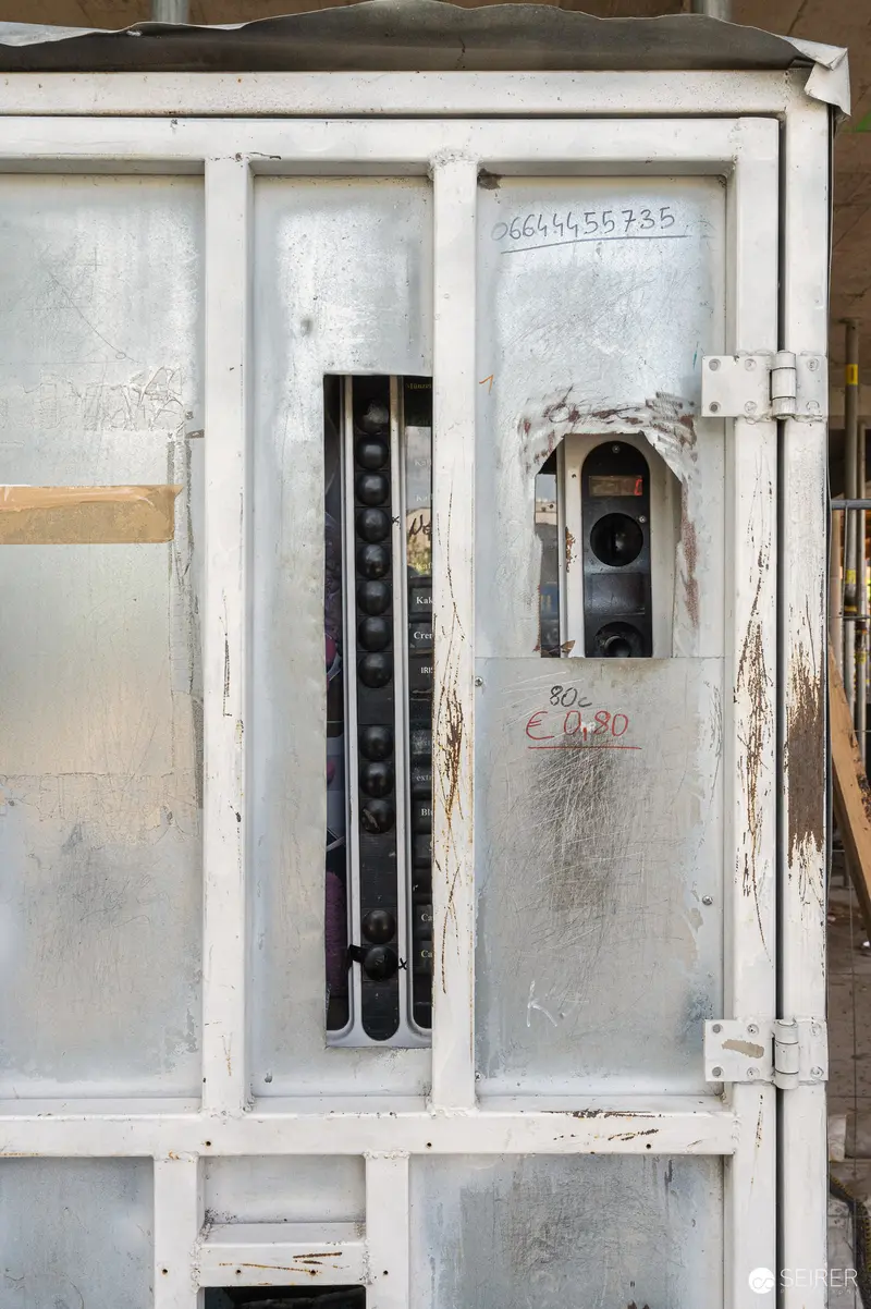 Weathered White Electrical Panel with Vertical Measurement Markings in Construction Zone