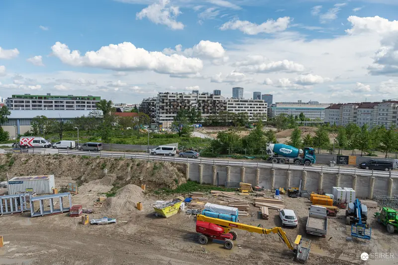Active Construction Site with Heavy Machinery Below Concrete Bridge