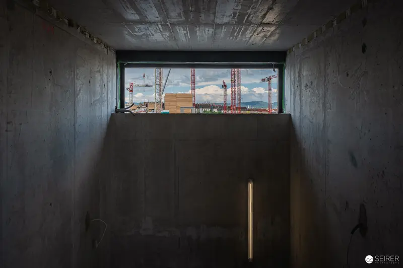 Underground Tunnel View of Construction Site with Red Cranes