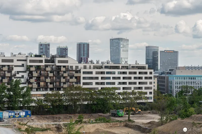 Urban Development Contrast: Modern Residential Building and Active Construction Site