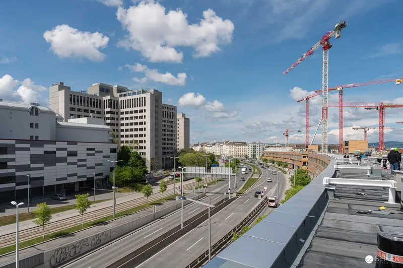 Major Urban Construction Site with Multiple Tower Cranes and Highway Infrastructure