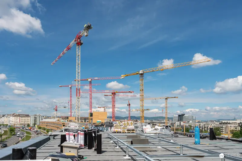 Construction Site Overview with Multiple Tower Cranes and Urban Skyline