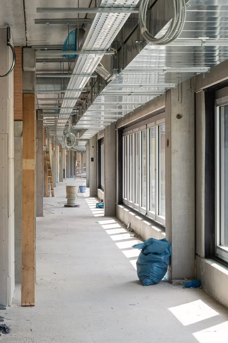 Construction Site Corridor with Exposed Ceiling Systems and Natural Light