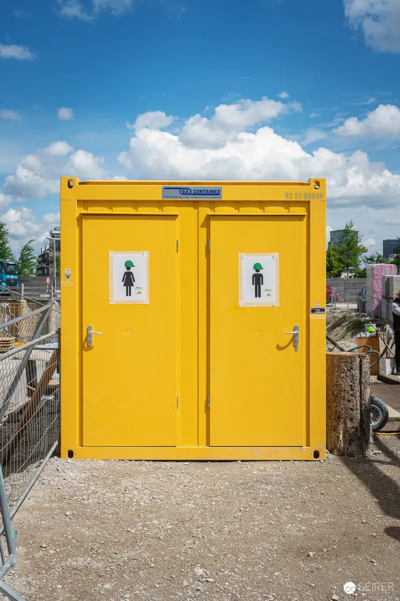 Yellow Portable Restroom Facility on Active Construction Site