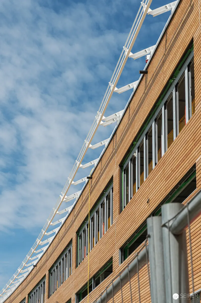 Modern Brick Facade with Angular White Sun Shades and Repetitive Window Pattern