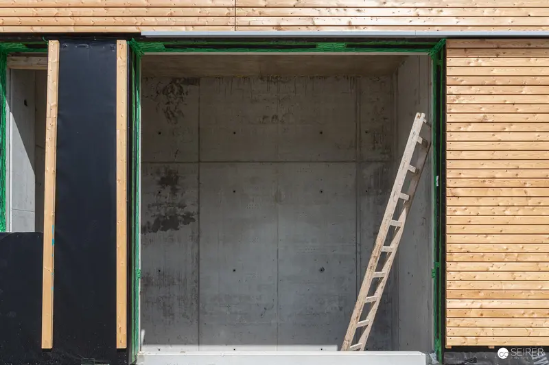 Construction Site Interior with Wooden Ladder and Concrete Walls