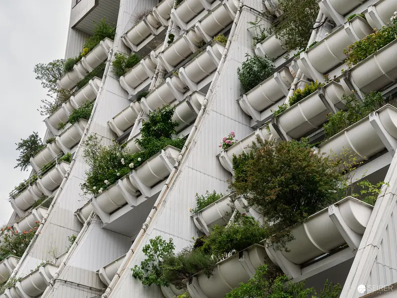 White Vertical Garden with Cylindrical Planters on Modern Building Facade