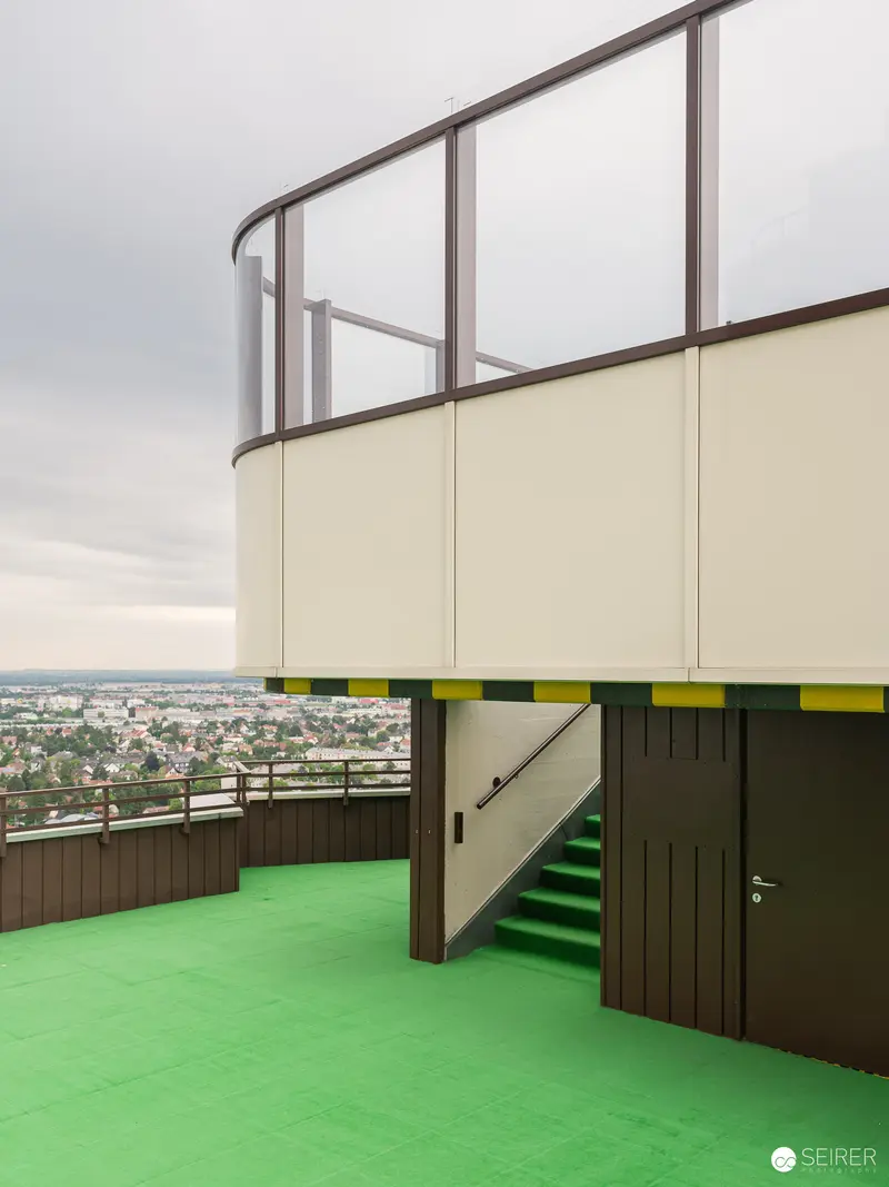 Green-Floored Urban Overlook with Curved Glass Balustrade and City Panorama