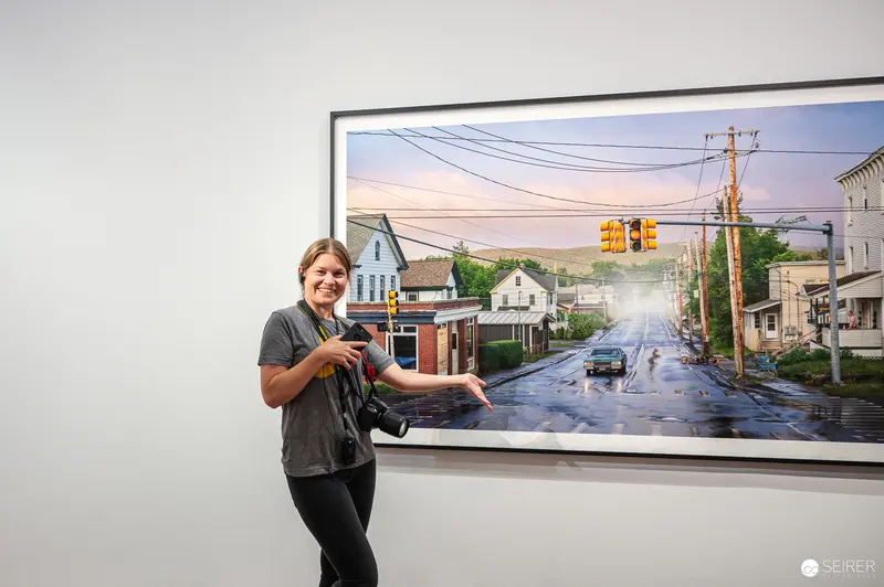 Visitor with camera points to Gregory Crewdson street photograph at Albertina Vienna