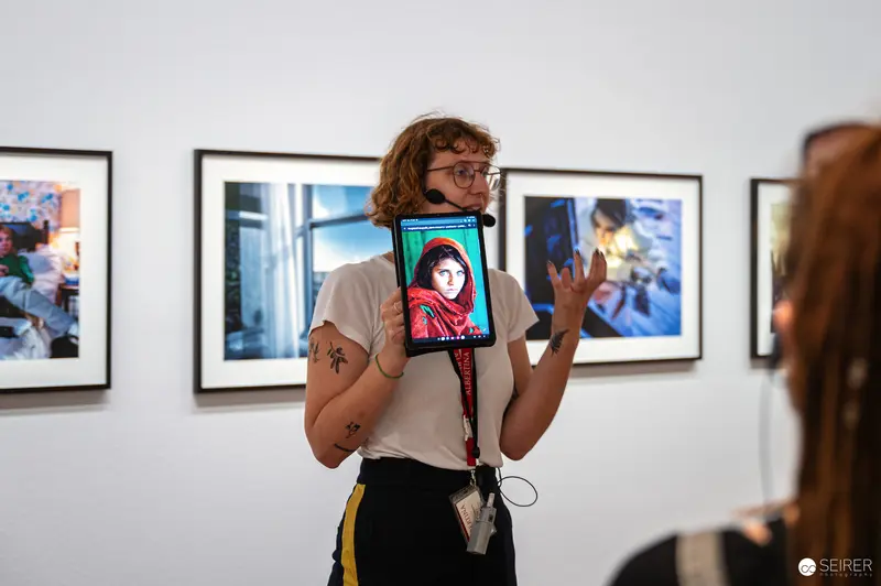 Albertina Guide Shows Steve McCurry's "Afghan Girl" on Tablet at Gregory Crewdson Exhibition