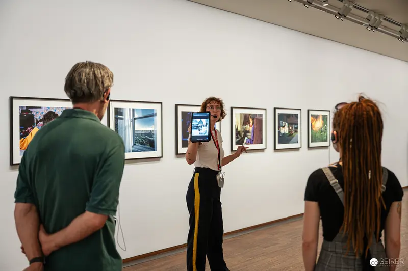 Albertina guide holds up tablet while leading Gregory Crewdson exhibition tour, Vienna 2024