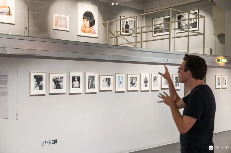 Liang Xiu Photography Exhibition: Curator Discussing Framed Black and White Portraits
