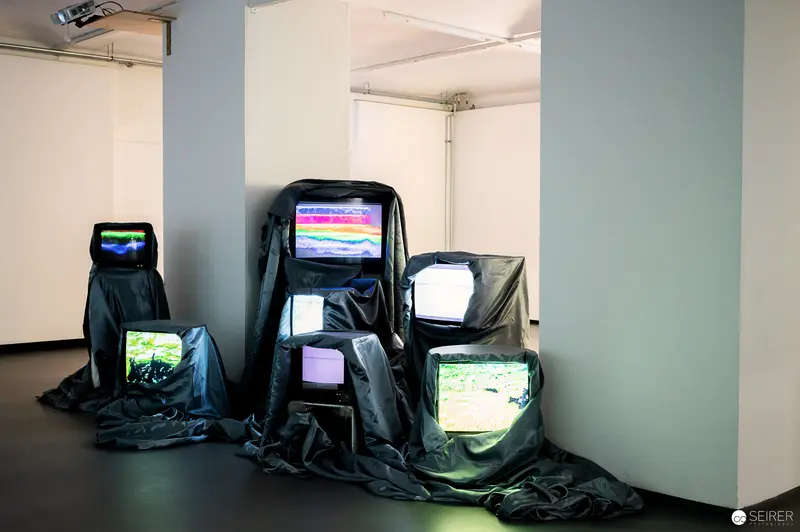 Electronic Art Installation with Glitching Television Screens in Dark Gallery Space