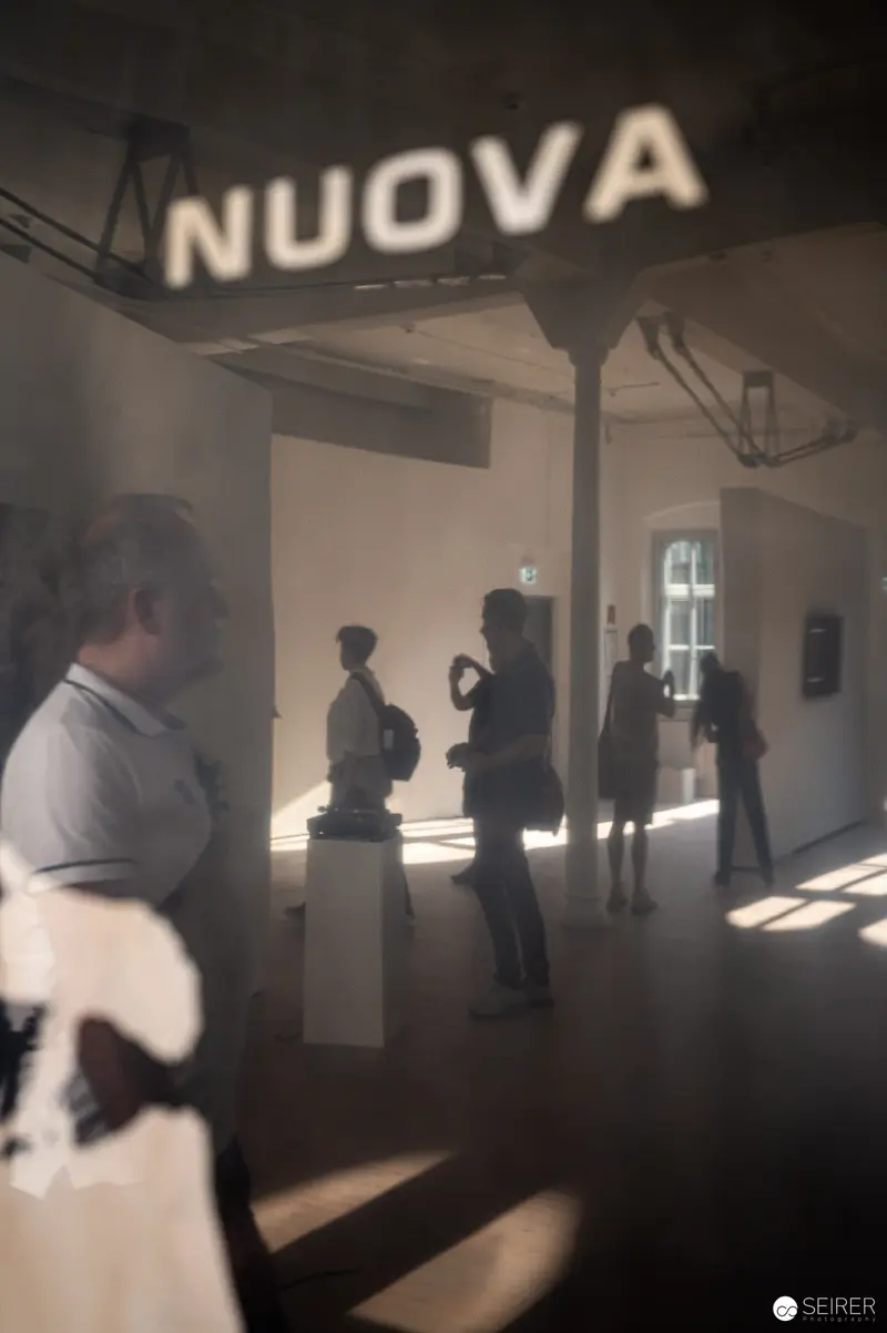 Interior View of Nuova Space with Silhouetted Figures in Atmospheric Light