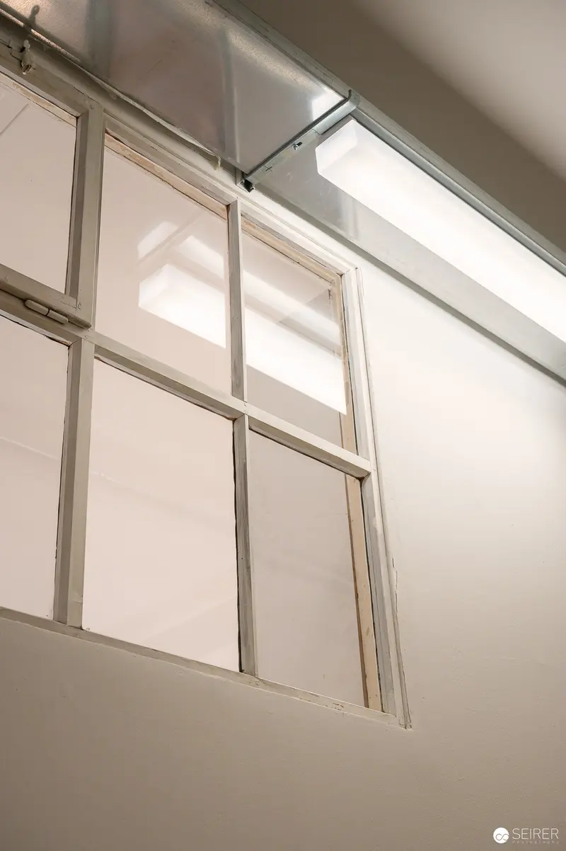 Minimalist Interior with Light Filtering Through Industrial Window Panes