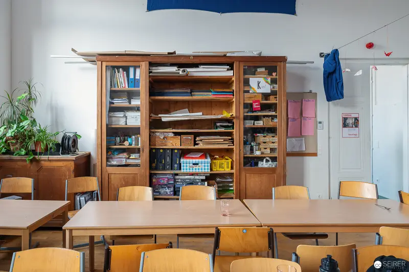 Wooden Bookcase and School Desks in Classroom Interior