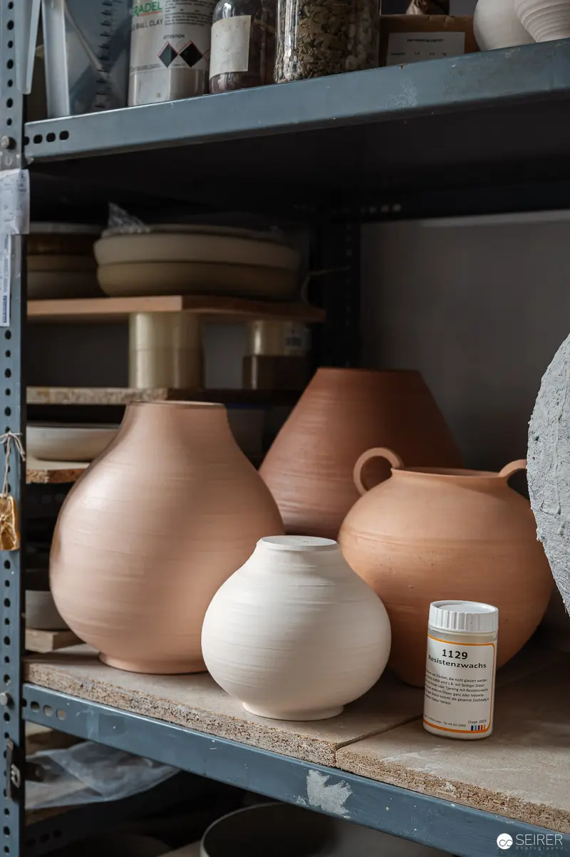 Ceramic Pottery Vessels on Industrial Shelving in Artisan Workshop