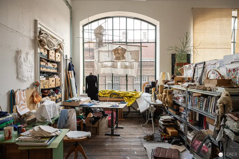 Artist's Cluttered Workspace with Clothing Design Materials and Vintage Furnishings