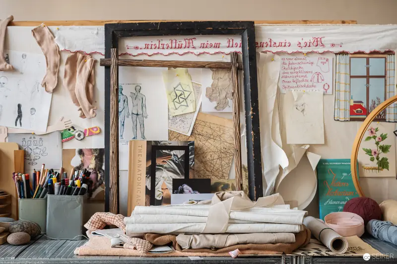 Artist's Studio Workspace with Sketches, Fabrics, and Design Materials