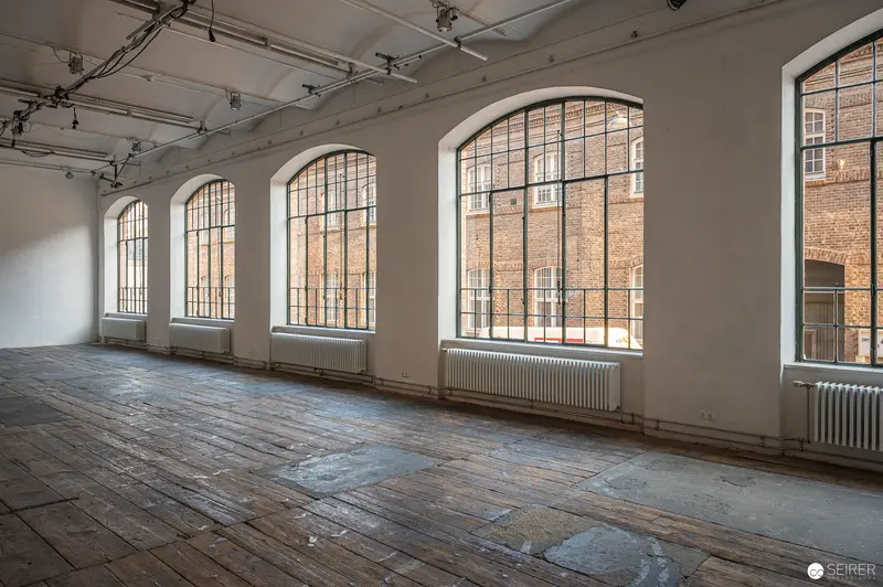 Empty Industrial Loft with Arched Windows and Weathered Wooden Floors