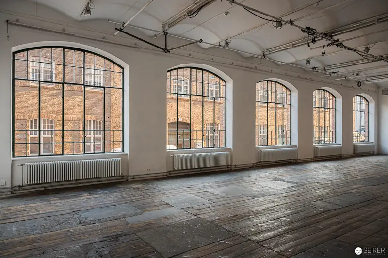 Empty Industrial Loft with Large Arched Windows and Weathered Wooden Floors