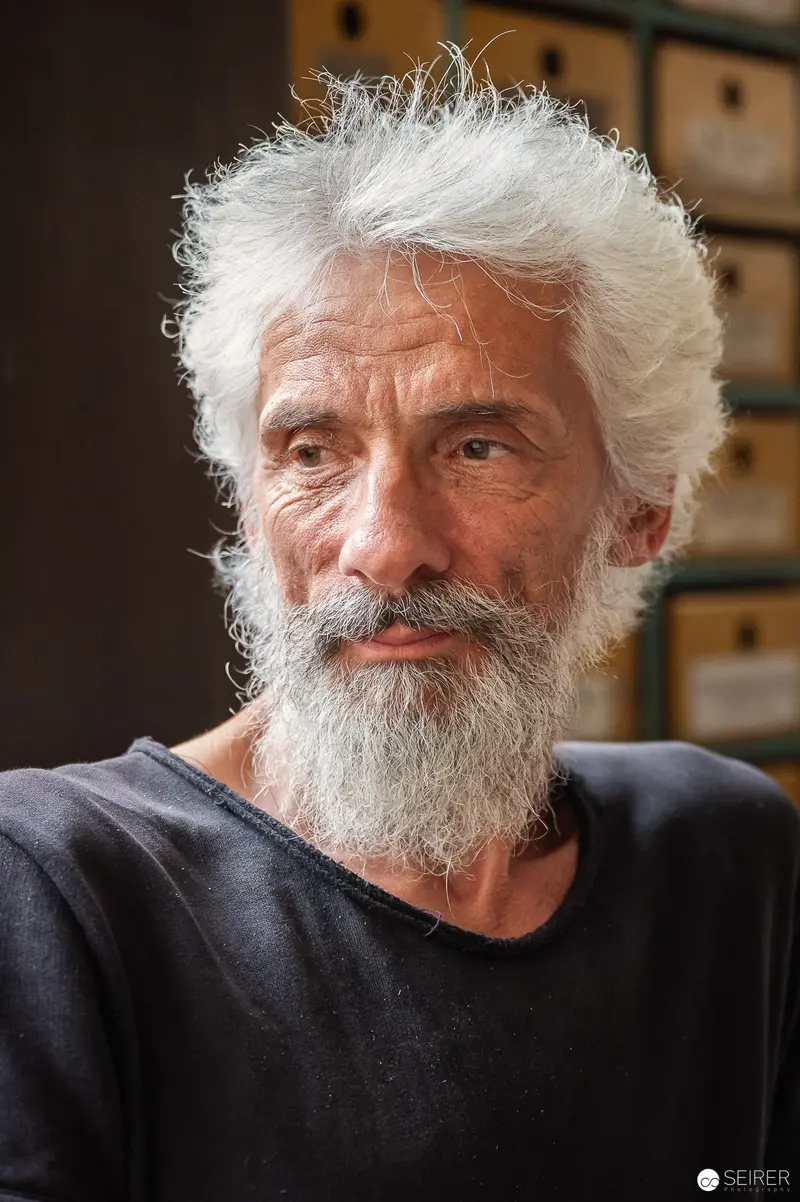 Weathered Portrait of Elderly Man with White Hair and Beard