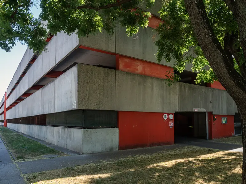Modernist Concrete and Red Architectural Building with Tree Shade