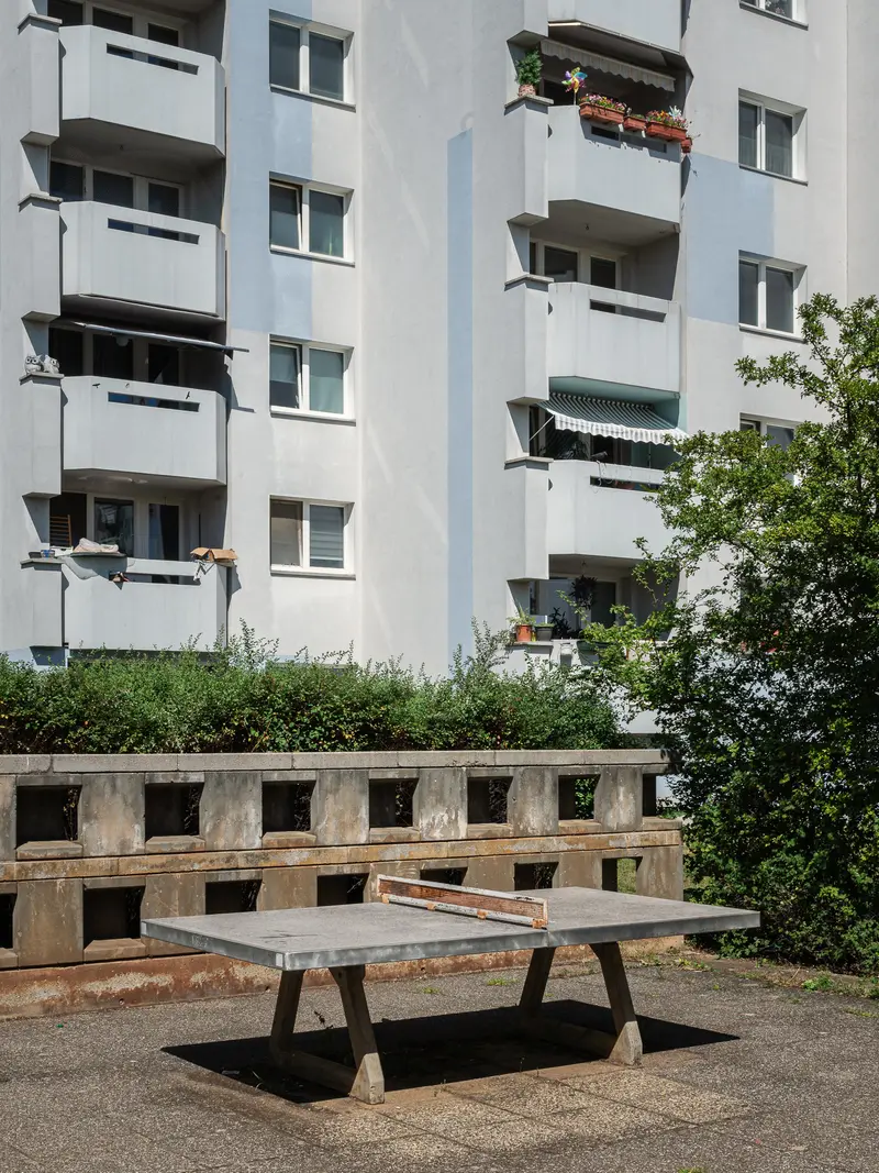 Urban Concrete Apartment Complex with Bench and Greenery in Vienna