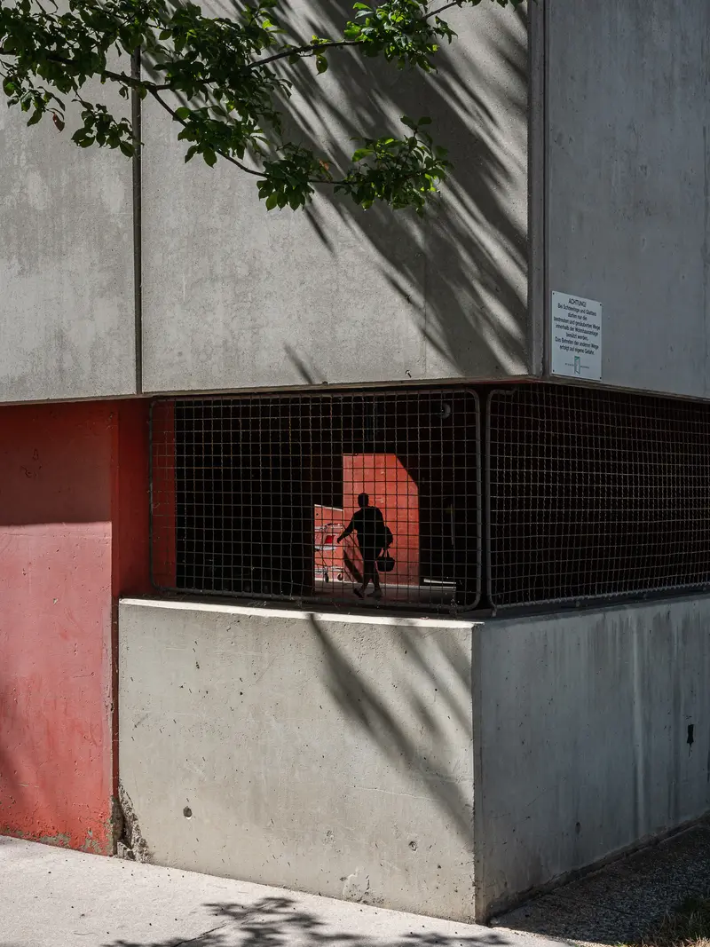 Solitary Figure in Geometric Urban Concrete and Metal Enclosure