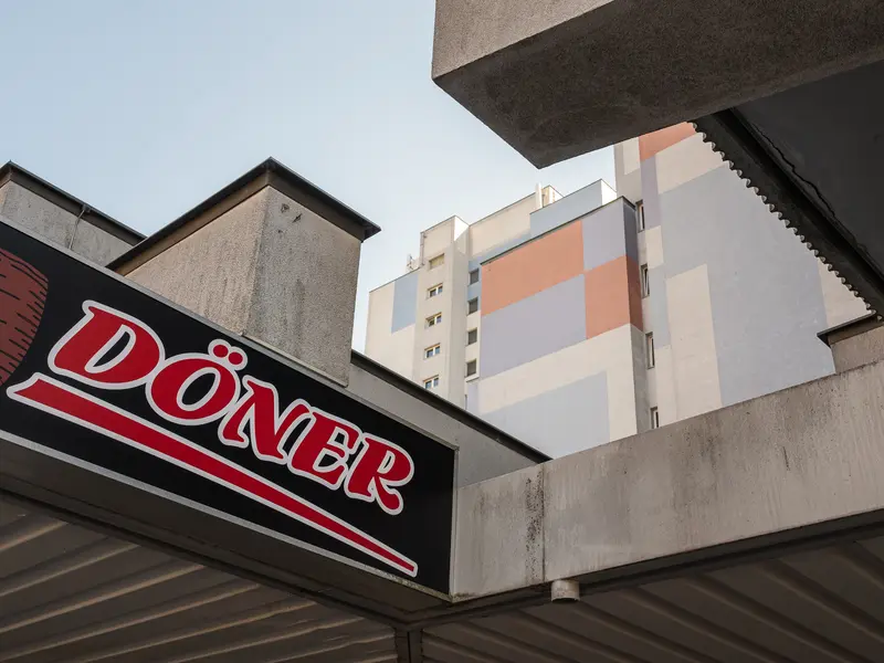 Doner Kebab Sign Against Urban Architectural Backdrop in Modern City