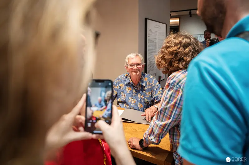 Martin Parr at Leica Gallery Vienna, August 22, 2024. Attendee Photographing Martin Parr During Book Signing at Leica Gallery Vienna