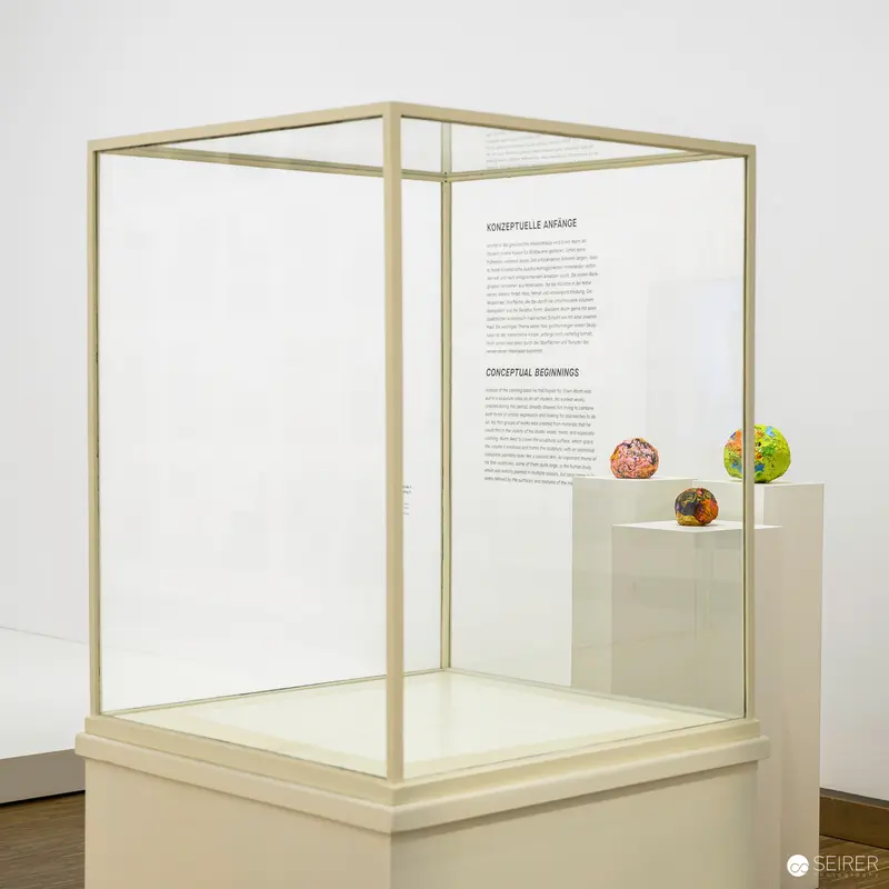 Minimalist Museum Display Featuring Three Small Spherical Objects