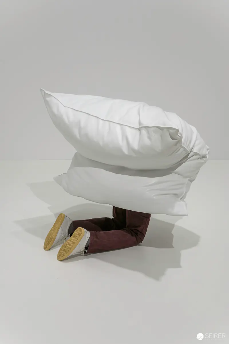 Erwin Wurm's Absurdist Sculpture: White Pillows and Shoes on Dark Surface