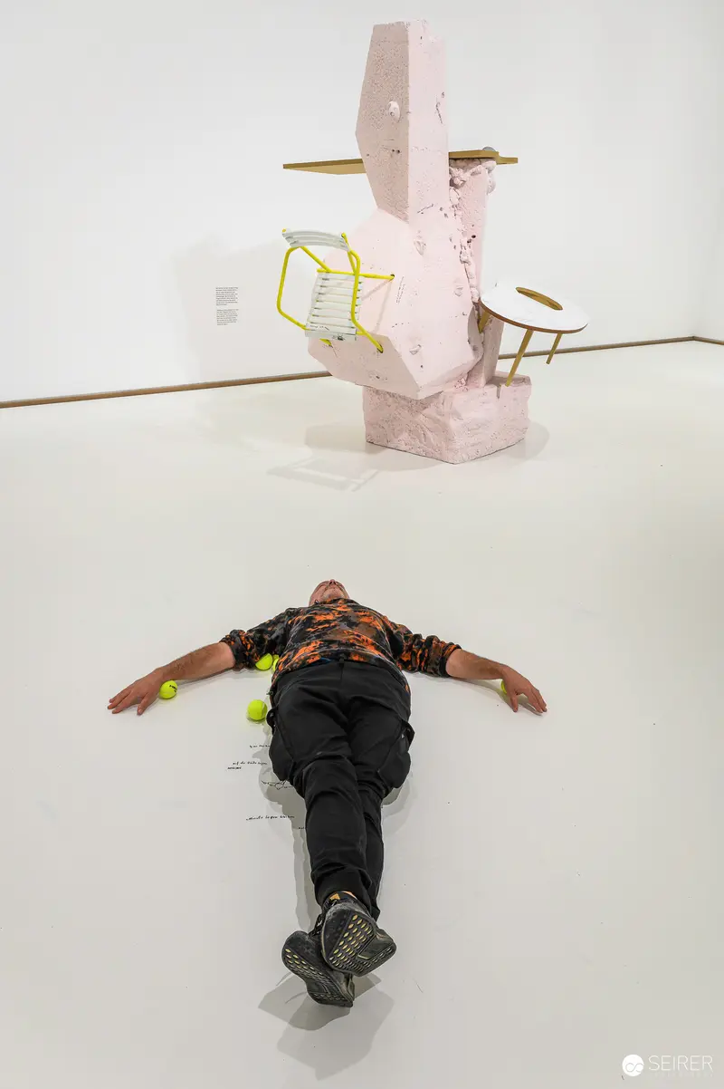 Erwin Wurm's Absurdist Performative Sculpture: Figure Sprawled on Gallery Floor