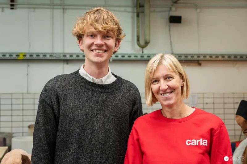Two Smiling Colleagues in Workshop Setting Wearing Casual Attire