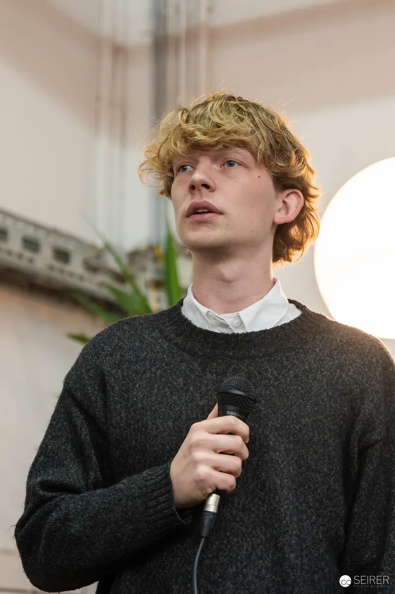 Young Performer Speaking with Microphone at Literary Event