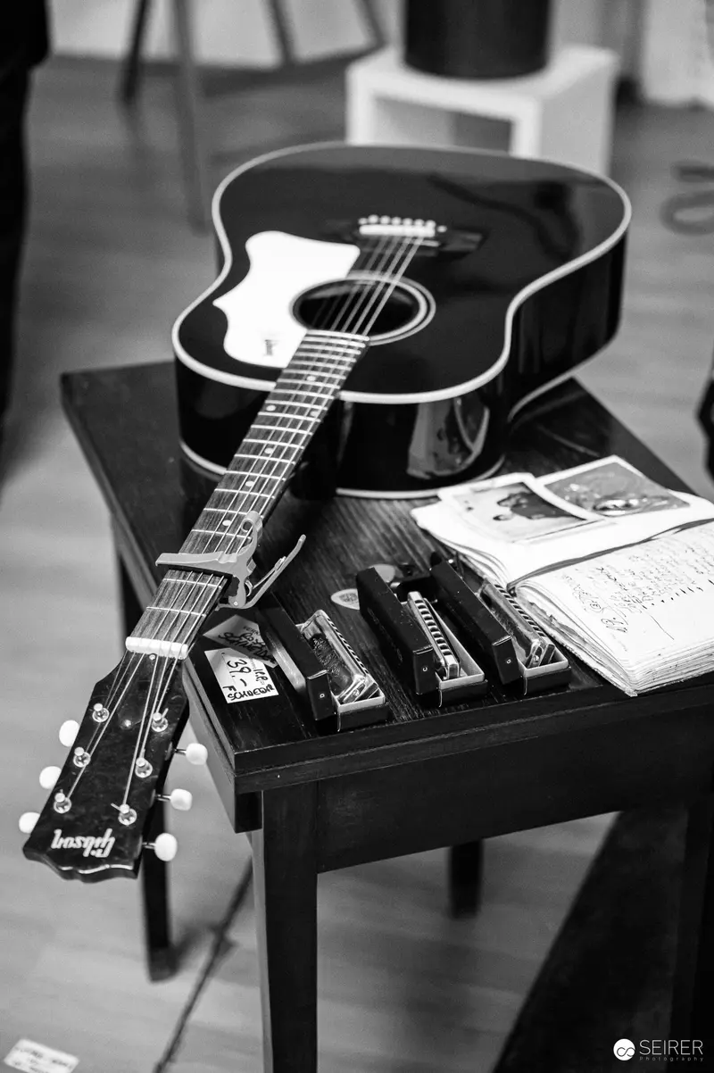 Acoustic Guitar and Harmonica on Vintage Side Table in Black and White