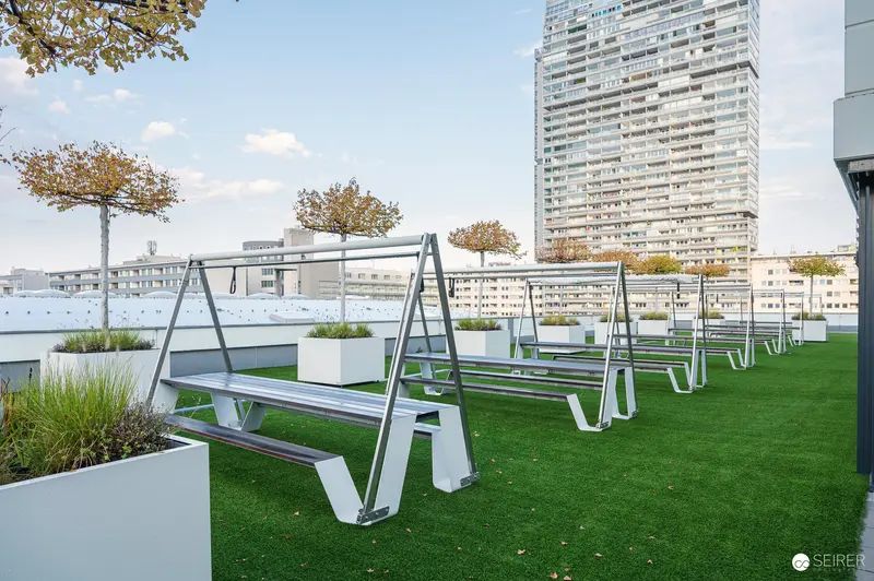 Modern Urban Rooftop Terrace with Geometric Seating and Architectural Backdrop