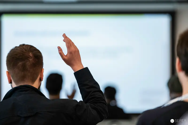 Corporate Conference Participant Raising Hand During Presentation at Vienna International Center