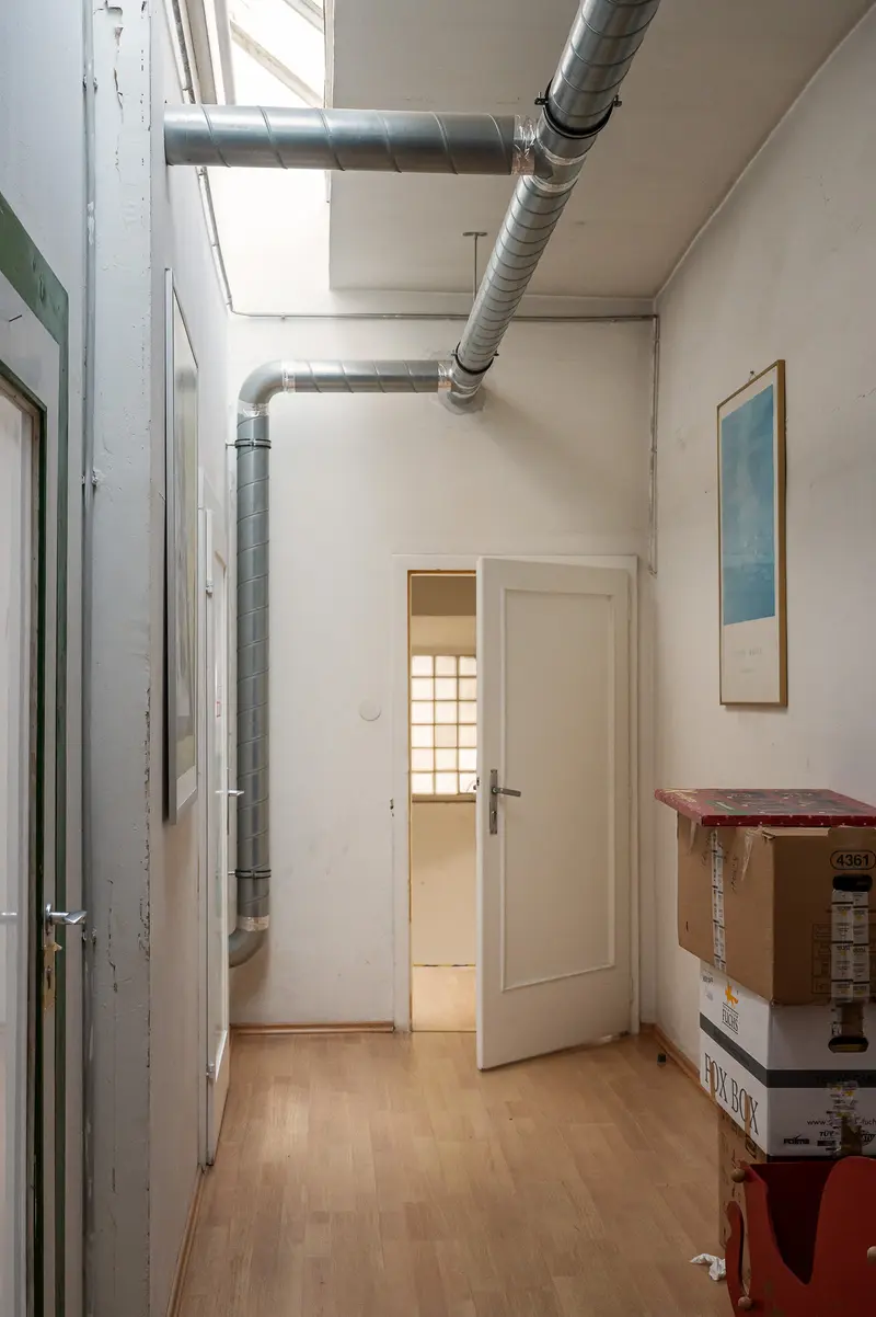 Interior Hallway with Exposed Pipes and Wooden Flooring