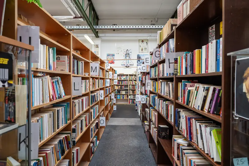 Wooden Bookshelves in Library Aisle with Alphabetical Sections